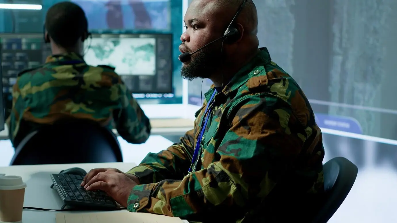 Военная комната управления с военнослужащими армии, контролирующими системы наблюдения.