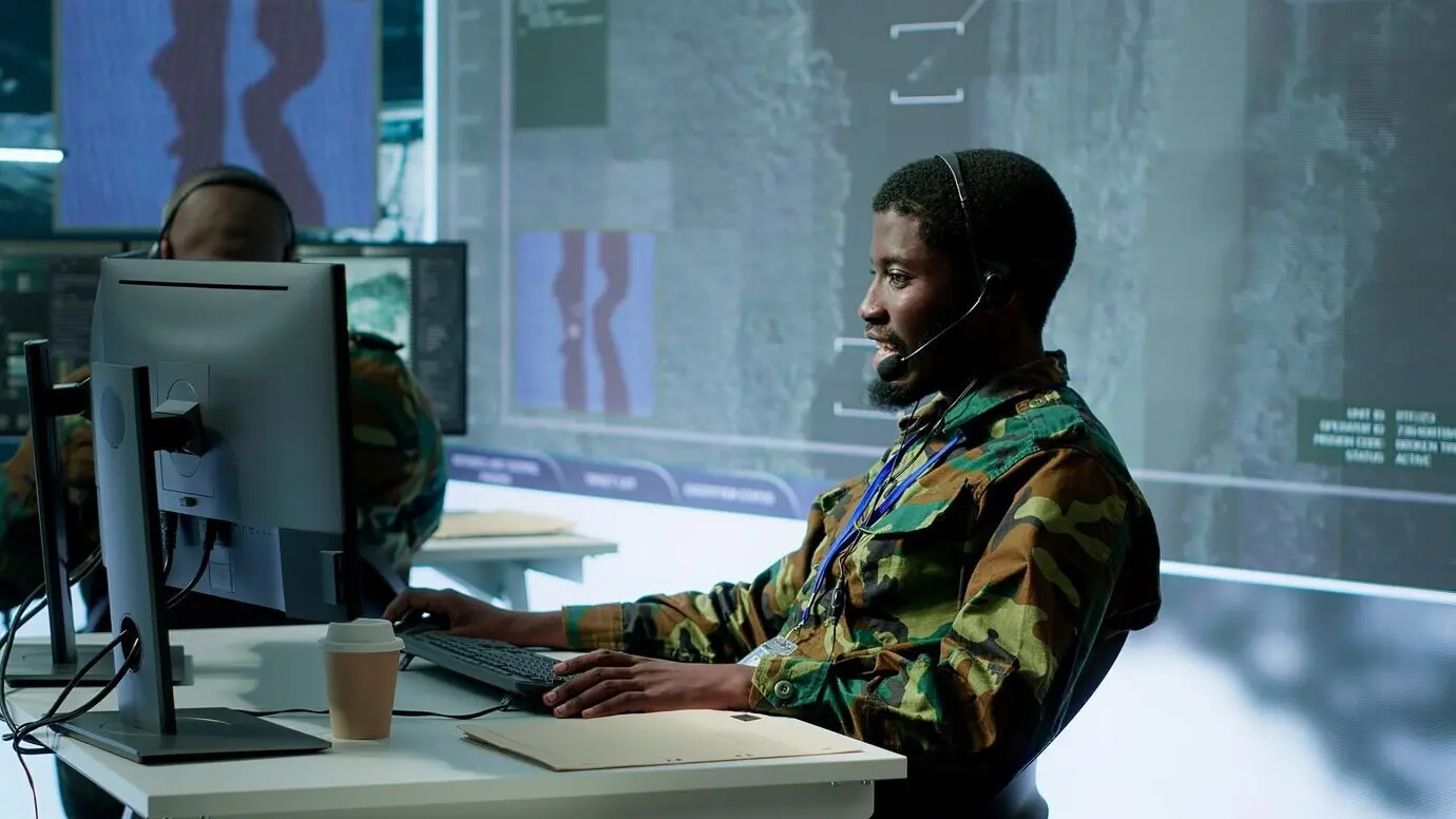 Группа военных специалистов в командном пункте, осуществляющая мониторинг спутниковых данных.